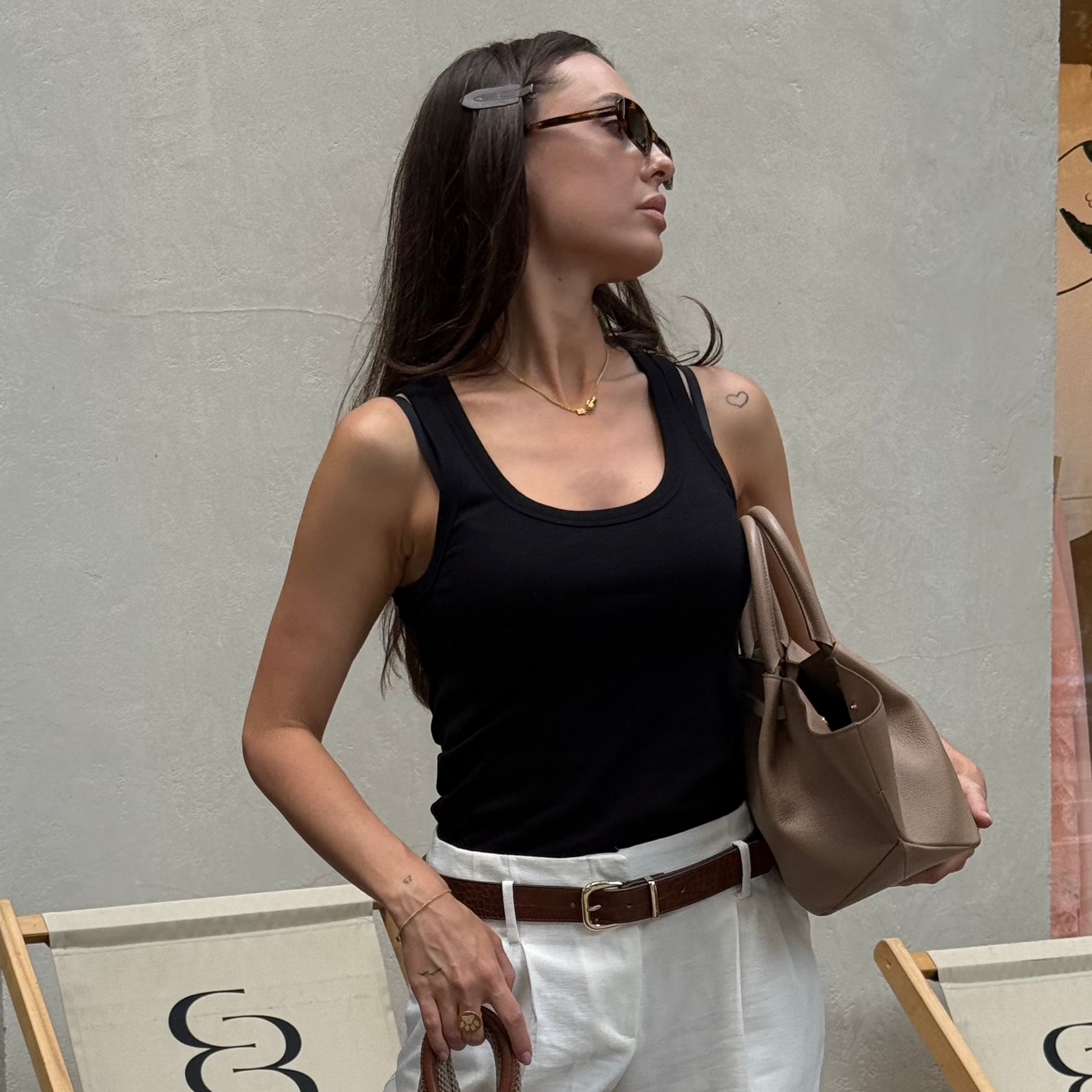 Дівчина в срібному кольє з позолотою від Лучі LUCHI тримає сумку